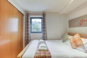 Habitación pequeña con cama y ventana en *Amazing Location!*In heart of the City. 2BR & Cot, en Edimburgo