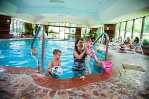 un grupo de niños jugando en una piscina en Evergreen Resort, en Cadillac