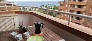 balcón con mesa y sombrilla en ACV Primera Línea, en Oropesa del Mar
