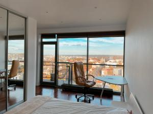 a bedroom with a bed and a table and chairs at Panoramic Apartment Vilnius in Vilnius