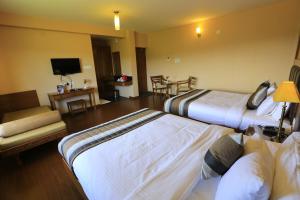 a hotel room with two beds and a television at Western Valley Resorts Ooty in Ooty +99 photos