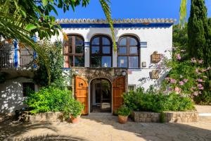a house with a lot of flowers in front of it at Villa Can Sarrio in Sant Carles de Peralta