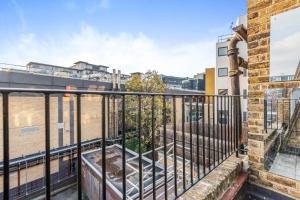 a balcony with a fence and a brick building at Central London-Modern Contemporary Flat in London