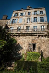 um edifício de tijolos alto com uma varanda em cima em Mercier de Montigny - Les Chambres du Beffroi - SPA et Massage em Fougères