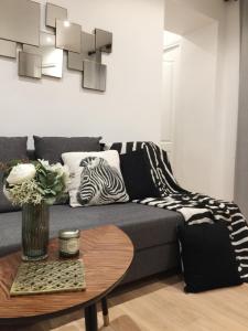uma sala de estar com um sofá azul com almofadas de zebra em Appartement Familial Au Coeur du Marais em Paris