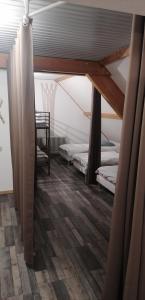 a attic room with two beds and a chair at Gîte la source de la bruche in Bourg-Bruche