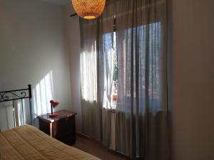 隆奇里翁雷的住宿－roncio' cottage，一间卧室配有床和带窗帘的窗户