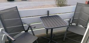 2 Stühle und ein Tisch auf dem Balkon in der Unterkunft Wohnung Sylter Brise in Wenningstedt-Braderup