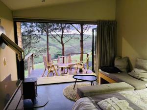 a bedroom with a balcony with a table and chairs at Valley View Pendle in Foulridge