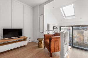 a living room with a television and a chair at Central London-Modern Contemporary Flat in London