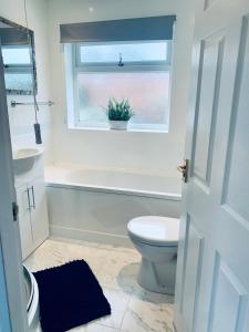 a bathroom with a toilet and a tub and a window at Homely Detached 3 bedroom house near Sheffield in Rotherham