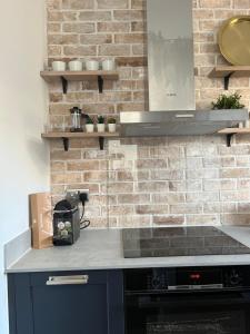 a kitchen with a stove and a brick wall at Central London-Modern Contemporary Flat in London