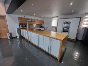 a kitchen with white cabinets and a wooden counter top at Sérénité - Espace Détente Ensival in Ensival