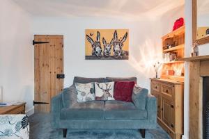 uma sala de estar com um sofá e uma pintura na parede em Brook Cottage em Temple Ewell