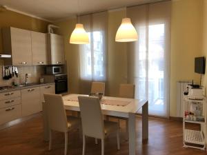 a kitchen with a table and chairs in a kitchen at Appartamento Vaniglia in Viareggio