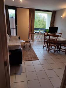 uma sala de estar com um sofá e uma mesa e uma sala de jantar em Your Stay in Kelmis - La Calamine- Cosy apartment in the Ardennes -Three-country point em Kelmis