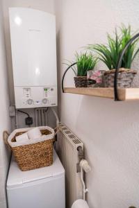 a bathroom with a toilet and two plants on a wall at Au Château de vos rêves in Montbéliard