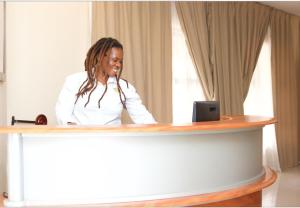 a woman sitting at a desk with a microphone at D'Villa Rest Inn in Gaborone