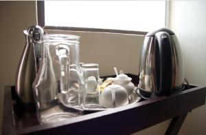 a shelf with glass jars and a tea kettle at D'Villa Rest Inn in Gaborone