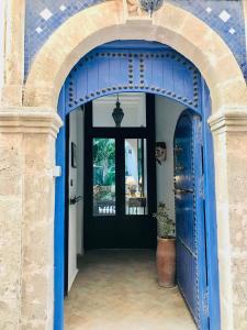 einen Eingang zu einem Haus mit einer blauen Tür in der Unterkunft Riad Dar Awil in Essaouira