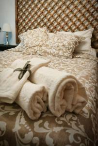 uma cama com uma pilha de toalhas brancas em Piso 1km de Salinas em Raíces