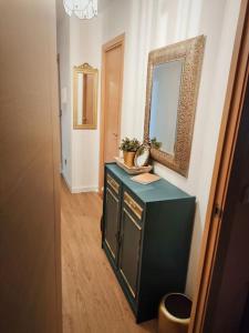 uma casa de banho com um armário verde e um espelho em Piso 1km de Salinas em Raíces