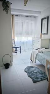 um quarto branco com uma cama e uma janela em Piso 1km de Salinas em Raíces