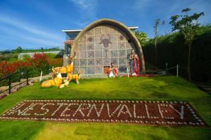 a house with a sign that says shanghai in the grass at Western Valley Resorts in Ooty