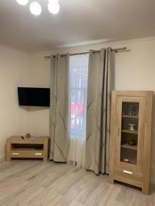 sala de estar con cortinas, TV y mesa en Dodo House, en Brasov