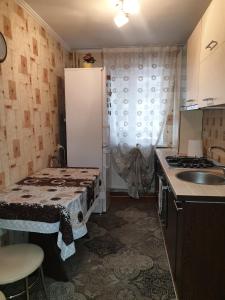 a kitchen with a table and a sink and a refrigerator at Alin Apartament in Iaşi