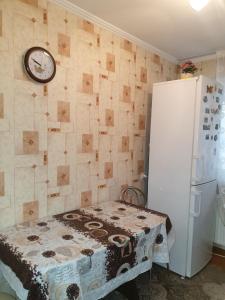 a kitchen with a table and a clock on the wall at Alin Apartament in Iaşi