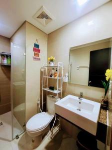 a bathroom with a toilet and a sink and a mirror at House of B&Y at 101 Newport across NAIA T3 in Manila