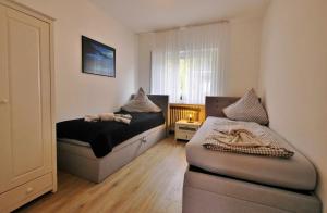 a bedroom with two beds and a ottoman at Quartier12 "Ski in & Bike out" - Fewo ZEIT in Willingen