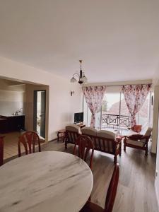 salon ze stołami i krzesłami oraz dużym oknem w obiekcie Blossom Silverpark Apartment w mieście Bukit Fraser