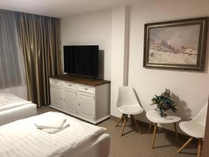 um quarto com uma cama e uma televisão de ecrã plano em HOTEL GALERIA PEZINSKA BABA em Pezinok