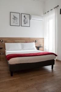 Maison L'amuri في باليرمو: سرير في غرفة نوم مع صورتين على الحائط