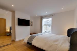 a bedroom with a bed and a large window at Bright Beautiful Modern 2 Bed Home Pass The Keys in Cambridge