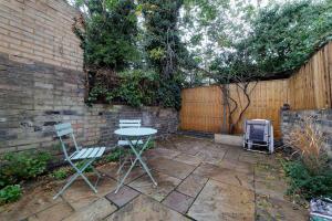a patio with two chairs and a table and a fence at Bright Beautiful Modern 2 Bed Home Pass The Keys in Cambridge
