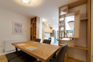 comedor con mesa de madera y sillas en Bright Beautiful Modern 2 Bed Home Pass The Keys, en Cambridge