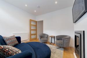a living room with a blue couch and two chairs at Bright Beautiful Modern 2 Bed Home Pass The Keys in Cambridge