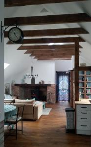 a living room with a couch and a clock on the ceiling at Forreset in Gietrzwałd