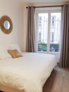 sypialnia z łóżkiem i dużym oknem w obiekcie New Apartment in the Heart of Le Marais w Paryżu