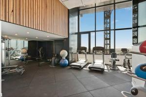 a gym with cardio equipment in a large room with large windows at Amazing views 60th level skytower 3 bedrooms in Brisbane