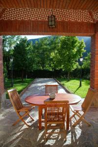 a wooden table and chairs under a pavilion at La Torre de Guardiola in Guardiola de Berguedà