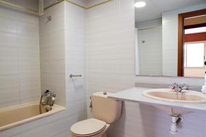 een witte badkamer met een toilet en een wastafel bij Arquus Park in Salou