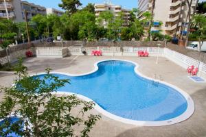a large swimming pool with red chairs around it at Arquus Park in Salou