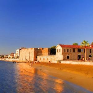 een strand met een groep gebouwen en het water bij Hai Hotel in Larnaka