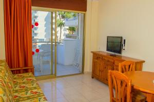 a living room with a table and a tv and a dining room at Arquus Park in Salou