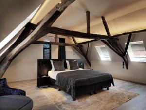 a bedroom with a bed in a room with exposed beams at Hotel Harmony in Ghent