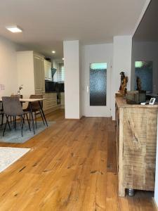 una cucina e una sala da pranzo con pavimento in legno massello di Appartement Seenähe mit gratis Tiefgaragenplatz a Seewalchen